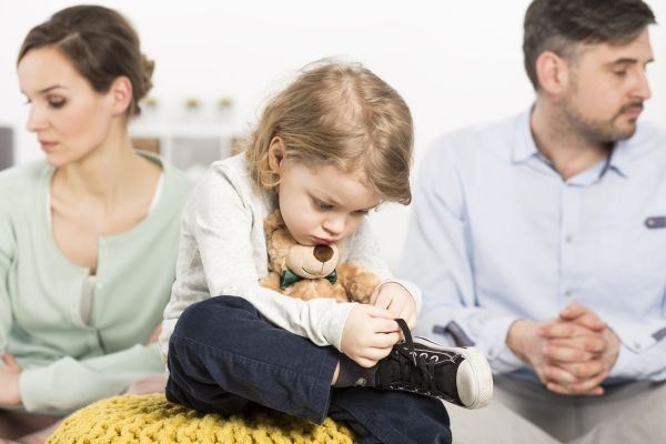 Sad Child Sitting Between Two Divorced Parents
